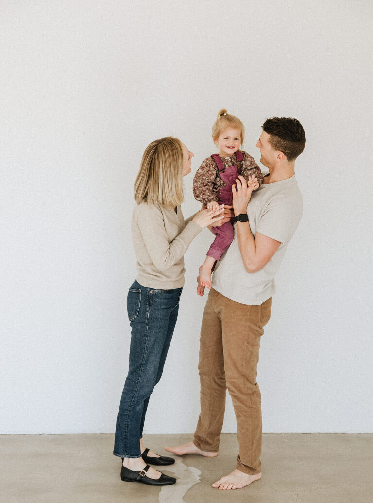 image of a mom and dad holding their two year old daughter taken by Omaha family photographer, Haverlee Photography