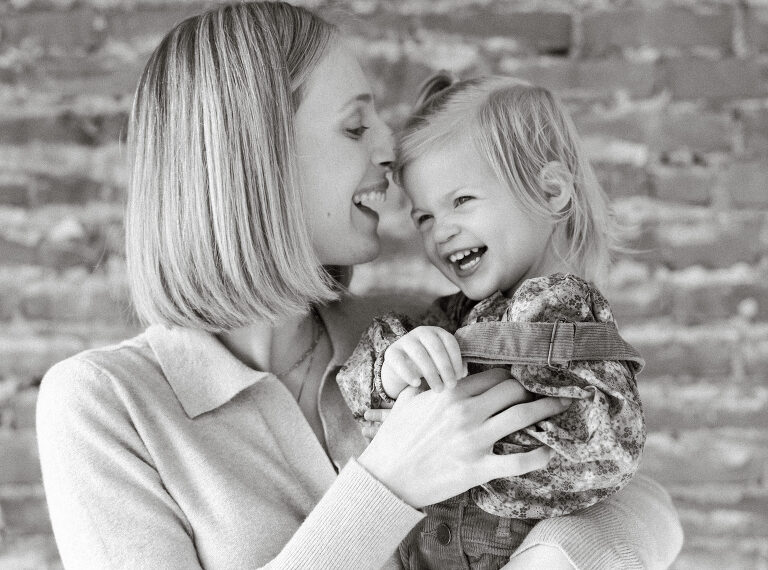 a black and white image of mom holding her daughter and laughing together during a family session in Des Moines by Asheville family photographer, Haverlee Photography