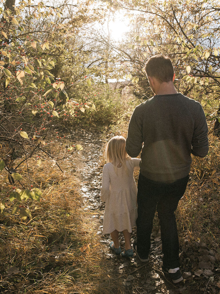 Dad and daughter walking through forest at Saylorville Lake family session by Iowa Family Photographer Haverlee Photography