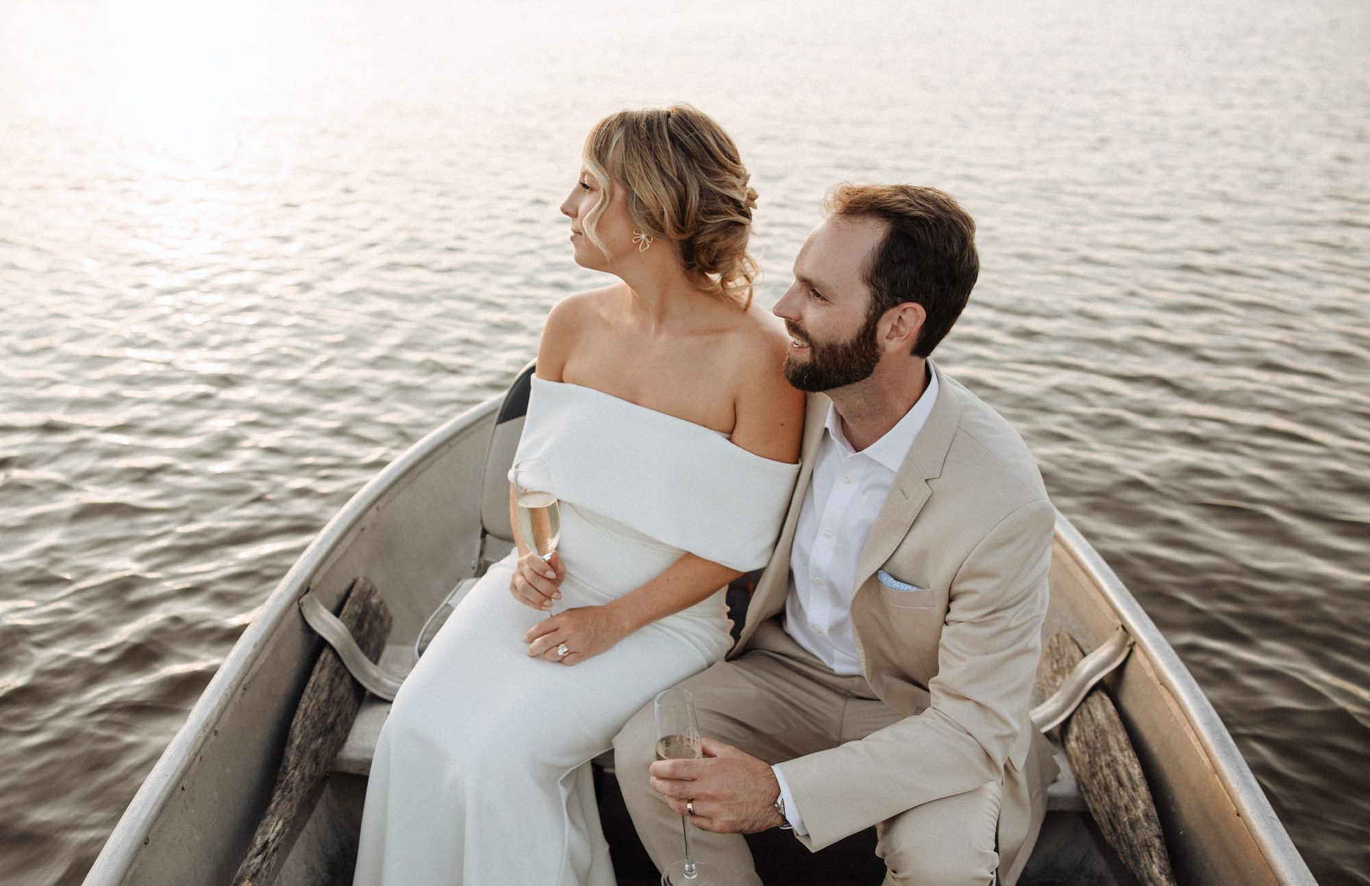 Bride and groom in a boat at golden hour on a lake in Minneapolis photographed by Haverlee Photography