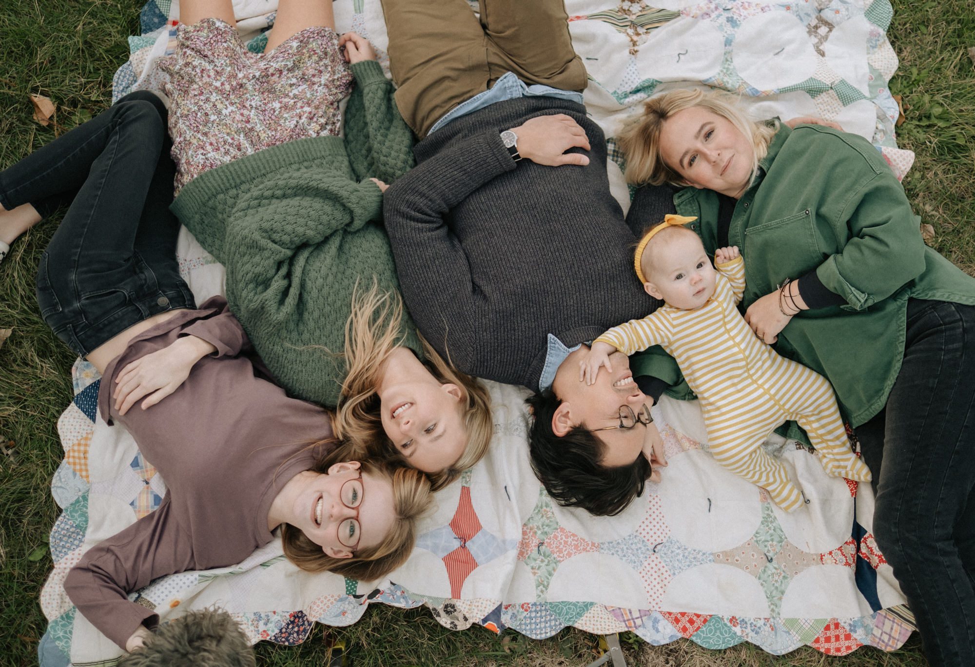 Family laying on a blanket in their backyard