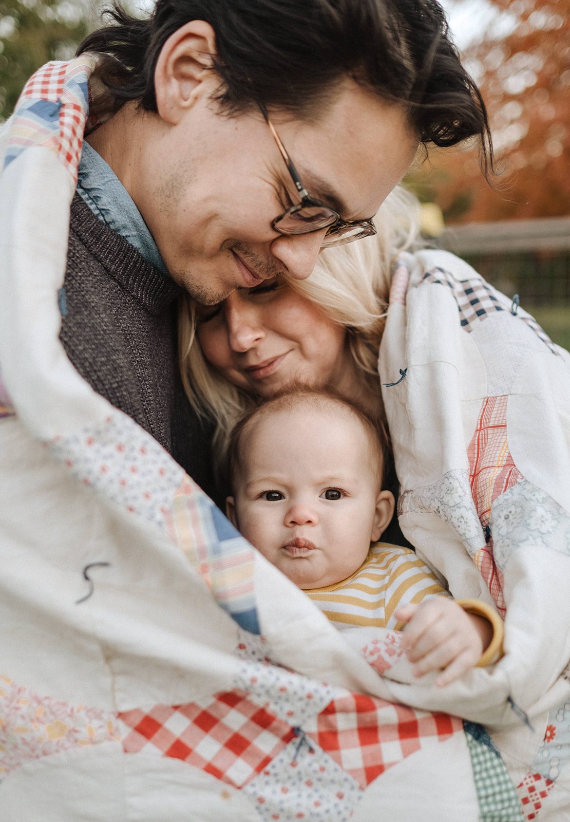 family snuggled in a quilt